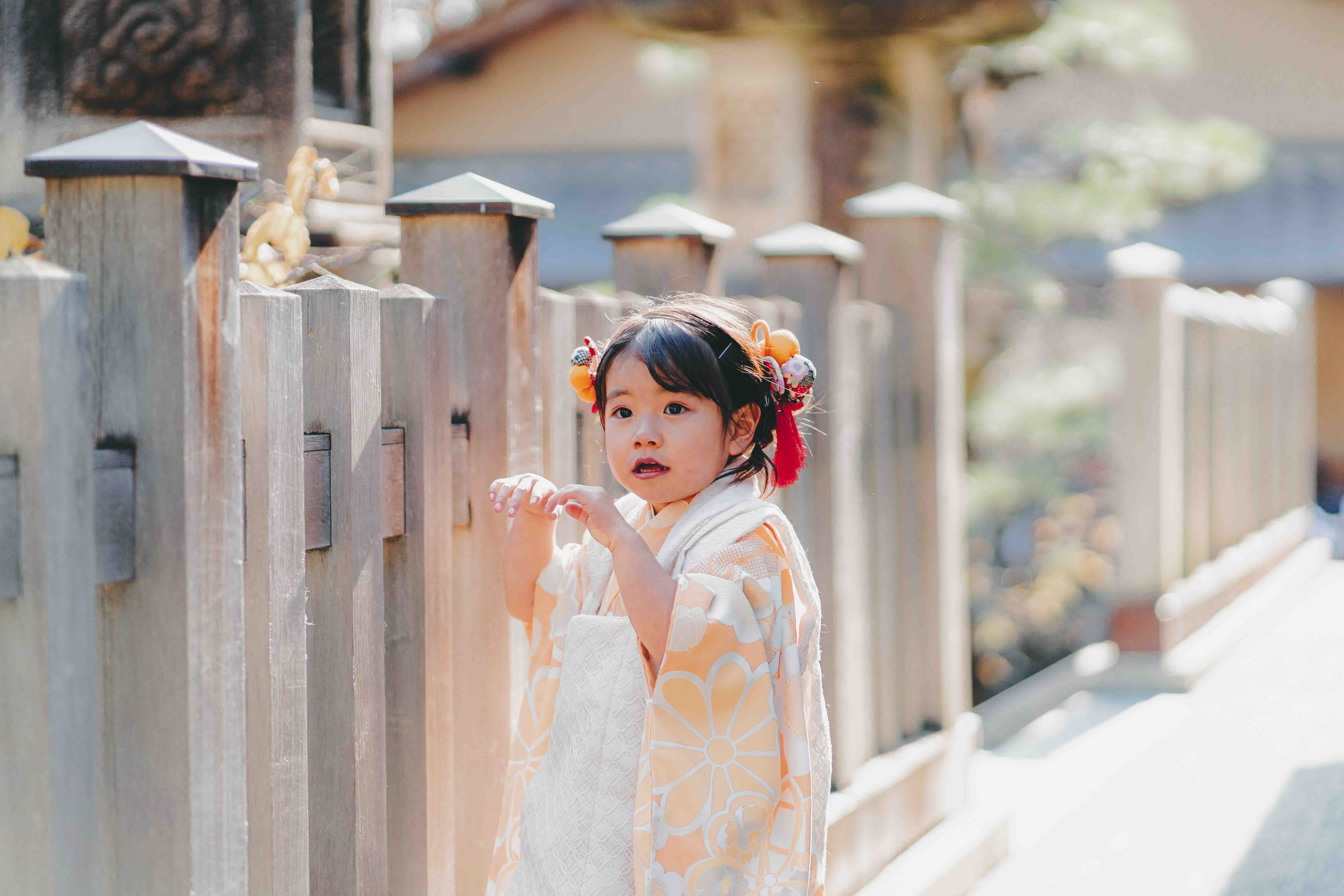 橙色の花柄着物の女の子が振り向く瞬間のポートレート