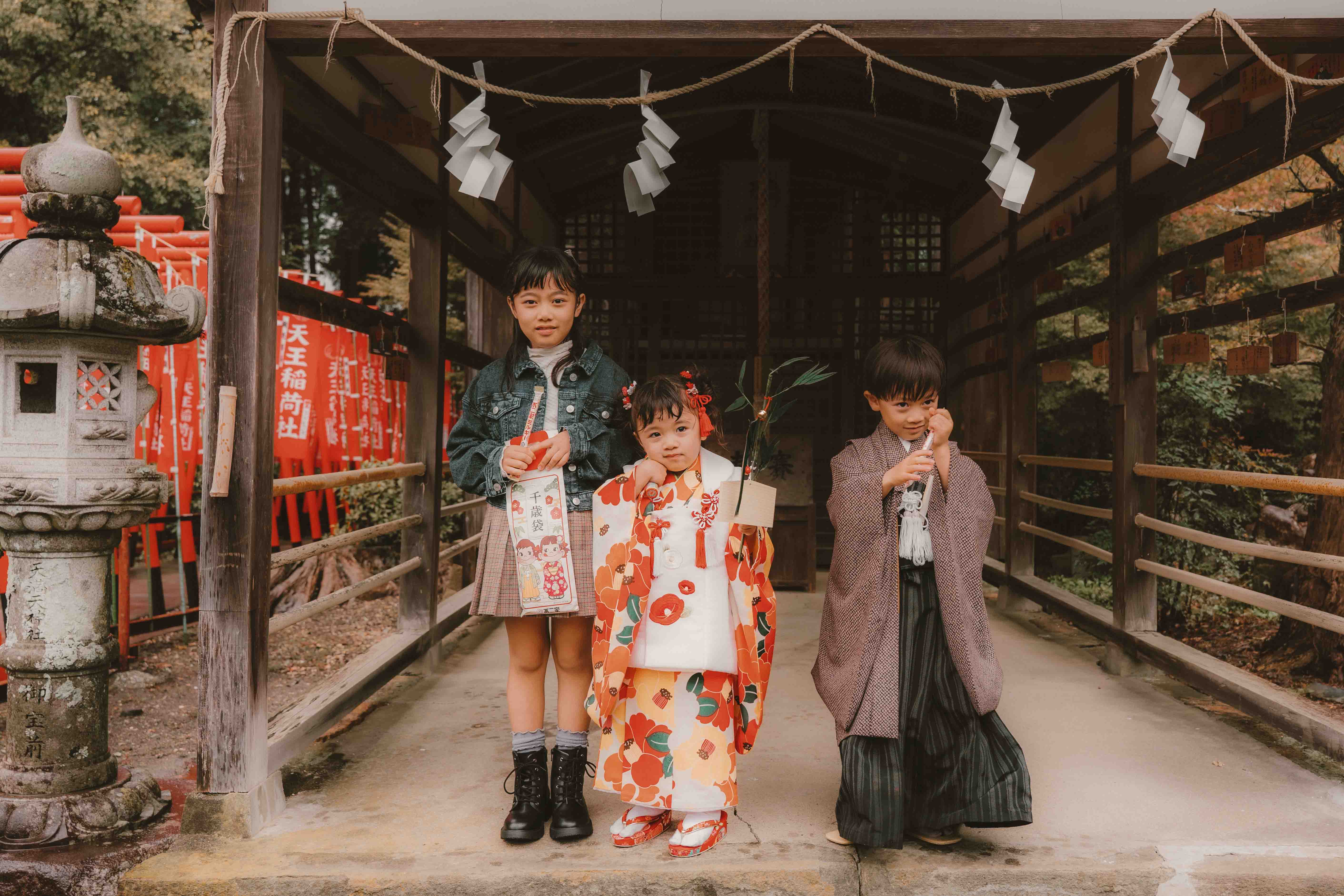 千歳飴の袋を手にした三人きょうだいの記念写真